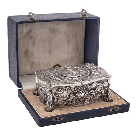 A Swiss Silver Plated Automaton Musical Box Of Serpentine Outline Decorated With Putti In Forest